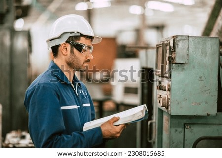 New Engineer Worker Reading User Manual Machine Instruction Guide Book to Working Operate Solving Problem in Metal Factory. Royalty-Free Stock Photo #2308015685