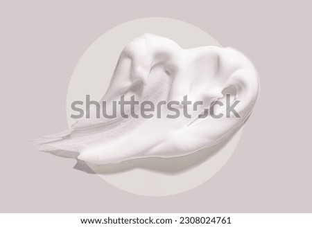 Cosmetic foam texture cleanser or shaving cream on gray circle background