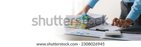Businessman working on stacks of documents to search for information and check documents on office desk
