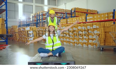 Storehouse Worker Having Fun On Job By Sitting On Pallet Jack. Happy Woman Rides Manual Pallet Jack In Storehouse. Warehouse Loader Royalty-Free Stock Photo #2308069267