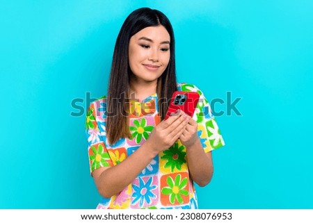 Photo of cheerful positive woman dressed flower print t-shirt texting iphone samsung apple gadget isolated teal color background