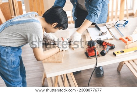 Southeast asian family father and son diy or repair at home concept. Dad teach using tools about carpenter or engineer education skill with child at workshop. Activity homeschooling. Royalty-Free Stock Photo #2308077677
