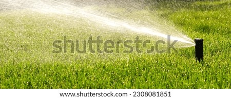Automatic garden irrigation system watering lawn. Savings of water from sprinkler irrigation system with adjustable head. Automatic equipment for irrigation and maintenance of lawns, gardening. Royalty-Free Stock Photo #2308081851