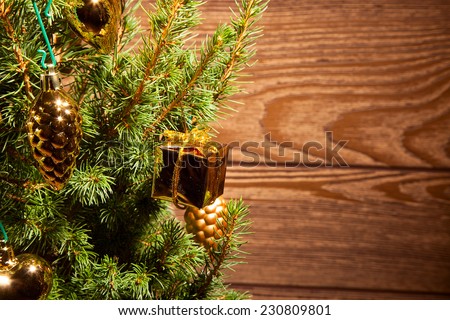 Spruce with golden decoration on the wooden background