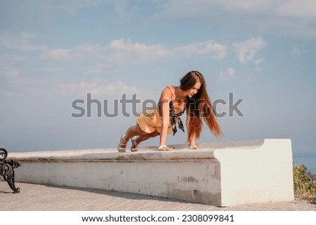 Woman park yoga. Side view of free calm bliss satisfied woman with long hair standing in morning park with yoga position against of sky by the sea. Healthy lifestyle outdoors in park, fitness concept.