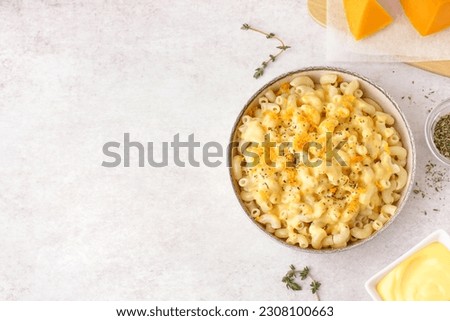 Bowl of tasty Italian pasta with Cheddar cheese on light background Royalty-Free Stock Photo #2308100663
