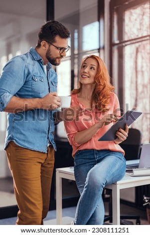 Business people, man and woman having coffee talking and looking at tablet. Royalty-Free Stock Photo #2308111251