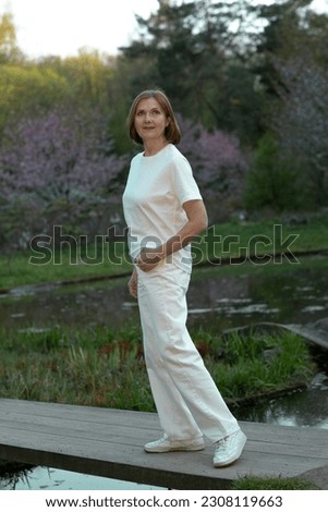 beautiful woman full body photo in Japanese summer garden with sakura blossom