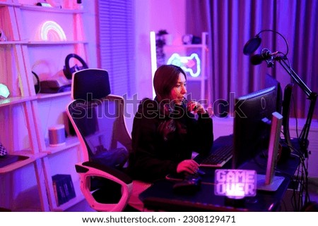 Asian streaming woman thinking and worry about strategy game and share tip and trick playing to her team in entertainment neon illuminate room