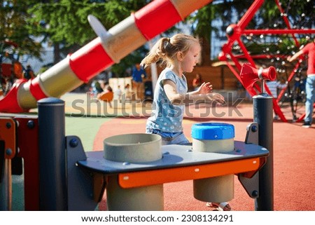 Adorable little girl on playground on a sunny day. Preschooler child playing outdoors. Outdoor summer activities for kids