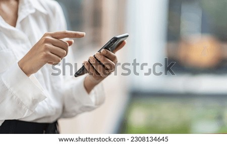 woman's hand with mobile phone Young woman tapping finger on blank screen of smartphone to click line and play social media online shopping job.