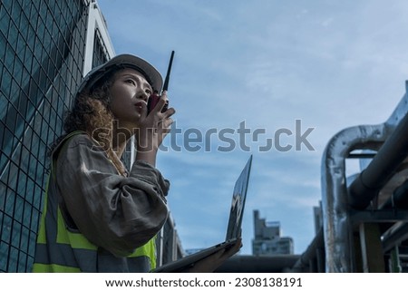 worker using radio communication on Air condition system plant on background. engineer female checking on Air condition plant. worker working on Air condition (HVAC).	