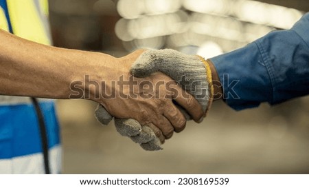 Business partnership meeting concept. Image of engineer handshake. Successful engineers handshaking after good deal. Horizontal, blurred industrial 
 Construction site background