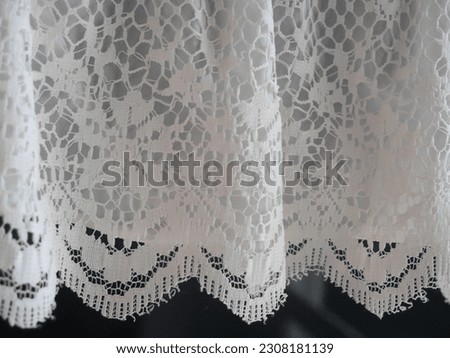 Picture of the surface of the white lace curtain curls. in natural light give a warm feeling Suitable for making background images.