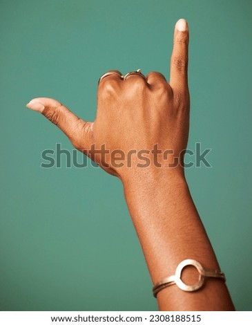 Woman, Shaka sign and hand in studio for surfer greeting, sign language and freedom. Emoji, icon and symbol of a female person with jewelry and hands for respect and hang loose on a green background