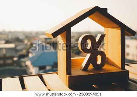 Percentage and house sign symbol icon wooden on wood table. Concepts of home interest, real estate, investing in inflation.	