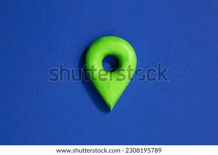Green location symbol of pin on blue background, 3d GPS pin icon made of plasticine, location concept.
