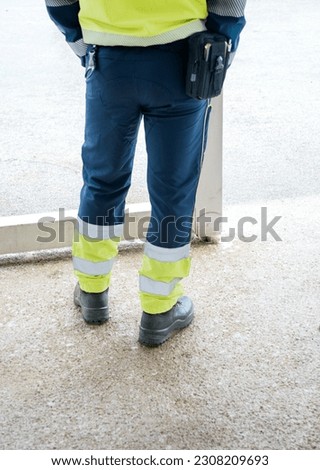 Legs with reflective pants and black working boots