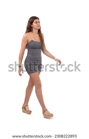 side front view of young girl with short dress walking on white background