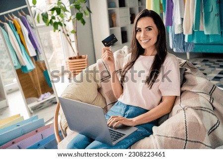 Photo of positive lady customer using netbook buying online store pay cashless with credit plastic card at home indoors showroom