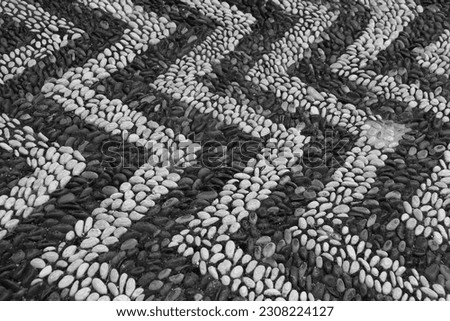 Round cobblestone rocks creating a chevron pattern walking path in The Kahal Shalom Synagogue (Synagogue of the Holy Congregation of Peace) in La Juderia, the Jewish quarter of Rhodes city