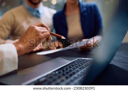 Close up of couple analyzing contract with bank manager in the office. 