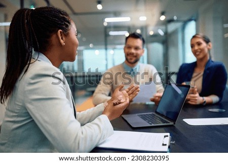 African American insurance agent communicating with her clients while counseling in the office. Royalty-Free Stock Photo #2308230395