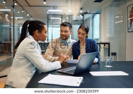 African American financial advisor analyzing documents with her clients on a meeting int he office. Royalty-Free Stock Photo #2308230399