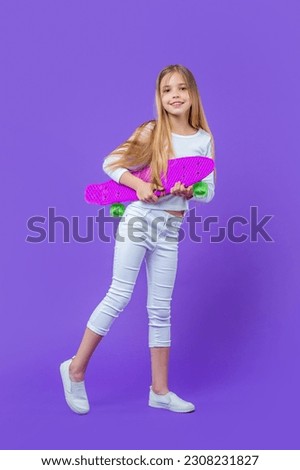 positive teen girl skateboarder isolated on purple. teen girl skateboarder in studio.