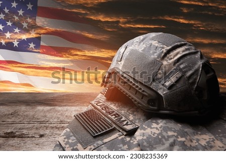 USA military uniform with insignias on old wooden table on sunset sky background with USA flag. Memorial Day or Veterans day concept.