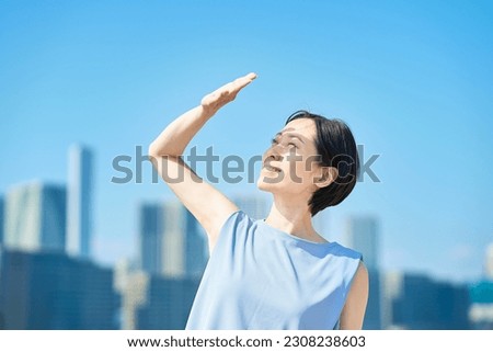 A woman blocking the strong sunlight under the blue sky Royalty-Free Stock Photo #2308238603