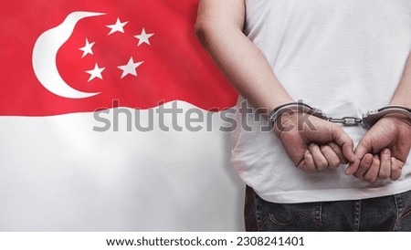 A man getting under arrest in Singapore. Concept of being handcuffed, detained, incarcerated and jailed in said country. National law enforcement concept. Royalty-Free Stock Photo #2308241401