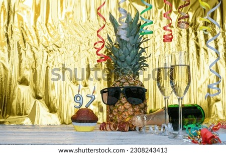 Cheerful pineapple in glasses festive happy birthday character with number  97. Beautiful background for congratulations copy space on a golden background with glasses of champagne. Anniversary