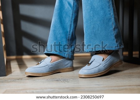 Slender female legs in jeans and blue loafers. Collection of summer women's shoes. Stylish women's shoes for summer Royalty-Free Stock Photo #2308250697
