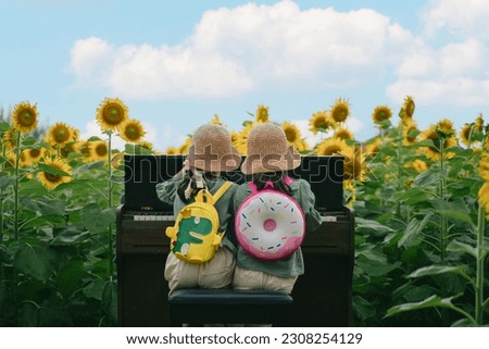 twin girls playing a piano in the Sunflower Field