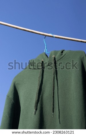 a green hoodie hangs in the air, wallpaper for the phone, wallpaper for the laptop Royalty-Free Stock Photo #2308263121