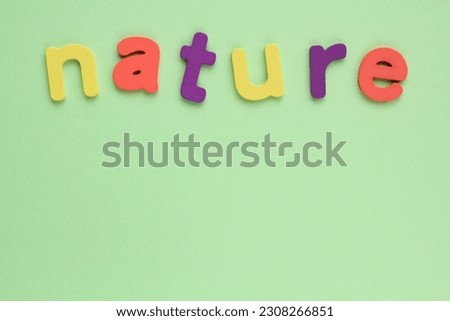 Colored letters Nature on green background. World Earth Day concept. Ecology green planet card. Environmental conversation and protection. Social banner, poster