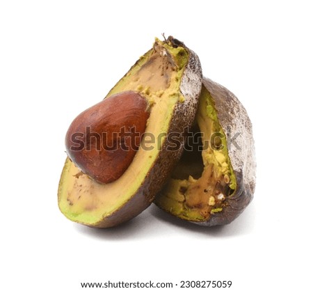 Over ripe avocado cut in half, isolated on white background