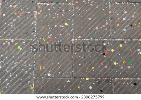 View from above of a street concrete floor covered with multi-colored Carnival confetti 