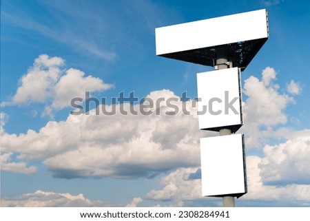 Mock up - three blank white billboards or large advertising displays against blue sky with white clouds. Consumerism, white screen, template, mock up and copy space concept