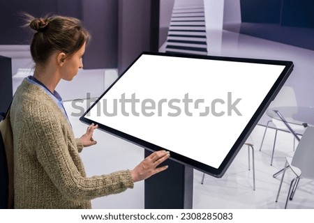 White screen, mock up, future, copyspace, template, technology concept. Woman looking at blank interactive touchscreen white display of electronic kiosk at futuristic exhibition or museum Royalty-Free Stock Photo #2308285083