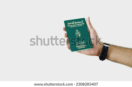 Man holding Tunisia Passport in hand on white background with copy space - Tunisian Royalty-Free Stock Photo #2308285407
