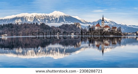 Panorama shot of lake Bled island church, bled castle and snow peak mountains during a winter afternoon, Bled, Slovenia Royalty-Free Stock Photo #2308288721