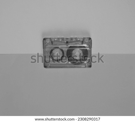 Audio cassette in the middle on a black and white color, top view.