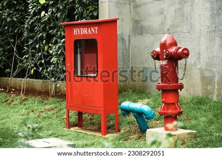 Red fire hydrant for emergency fire accsess in the front of building site. Close up shot of indonesian apartment hydrant.