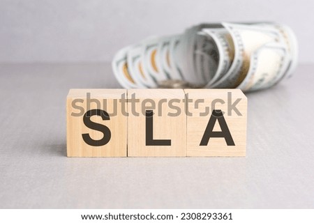 SLA - Service Level Agreement, wooden cubes with word, beautiful grey background, business concept