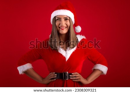 Very beautiful adult woman wearing Santa's hat and dress, in studio shot with red background, with space for text and making various facial expressions