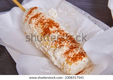 Elotes elote corn street food Mexican food dish cotija cheese spicy chili powder on white dish Royalty-Free Stock Photo #2308317541
