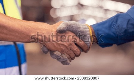 Engineer business industry partnership meeting concept. Image of engineer handshake. Successful engineers handshaking after good deal. Horizontal, blurred industrial 
 Construction site background