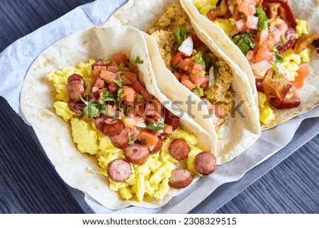 3 flour tortilla Mexican breakfast tacos sausage chorizo bacon with toppings asset